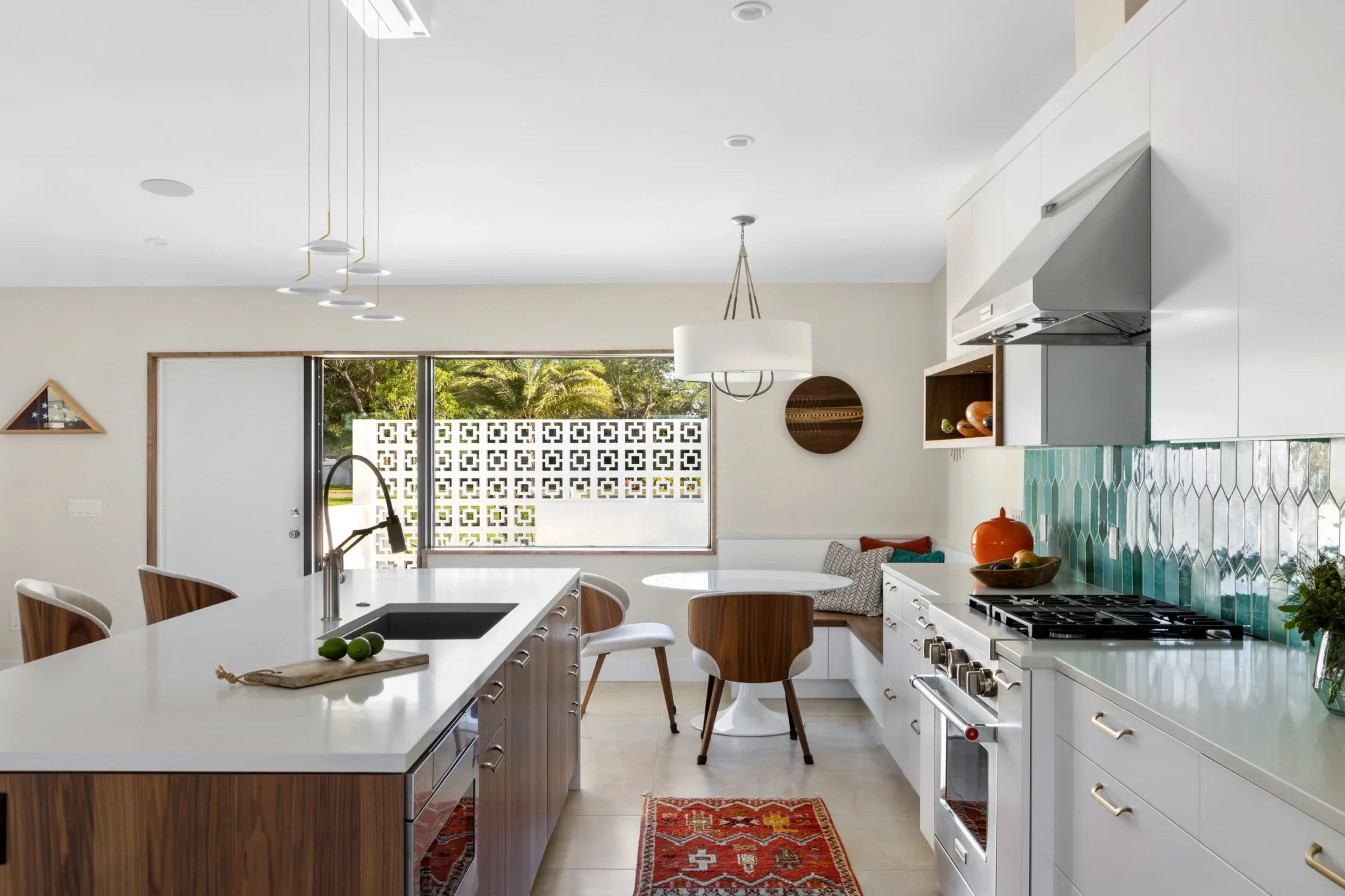 Modern kitchen with white cabinets, a central island with a wooden base, a gas stove, and green patterned backsplash tiles