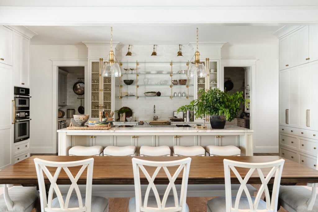 Kitchen and breakfast table with brass and glass shelving at Sarasota Country Estate, a custom home by Ross Built